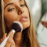 Vrouw brengt bronzer aan.