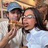 Man voert een stuk pizza een vrouw.