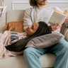 Koppel leest ieder een eigen boek cozy op de bank