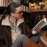 Meijse leest een boek in een bibliotheek