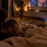 Koppel kijkt film onder een dekentje.